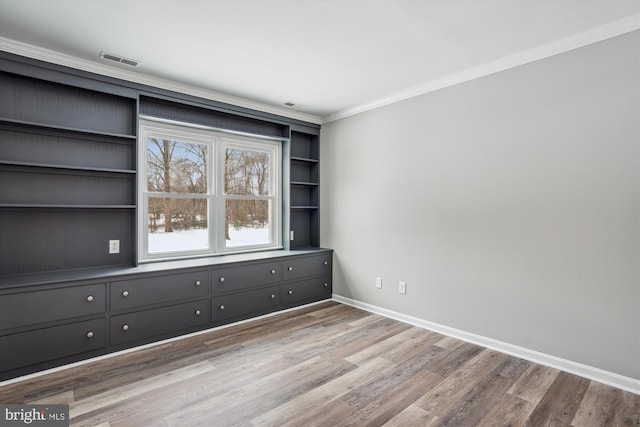 unfurnished room featuring light hardwood / wood-style flooring and crown molding