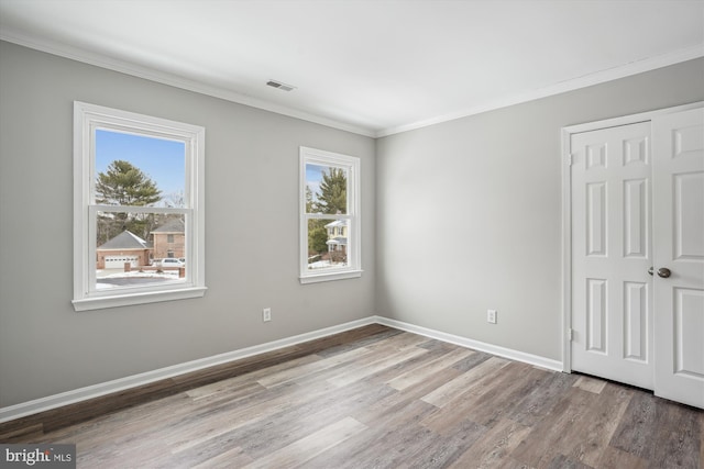 unfurnished bedroom with wood-type flooring and ornamental molding