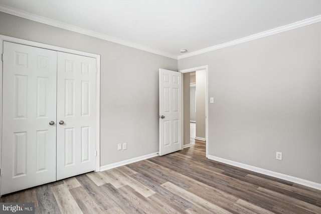 unfurnished bedroom featuring hardwood / wood-style floors, a closet, and ornamental molding