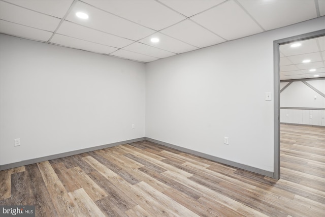 unfurnished room featuring light hardwood / wood-style floors and a drop ceiling