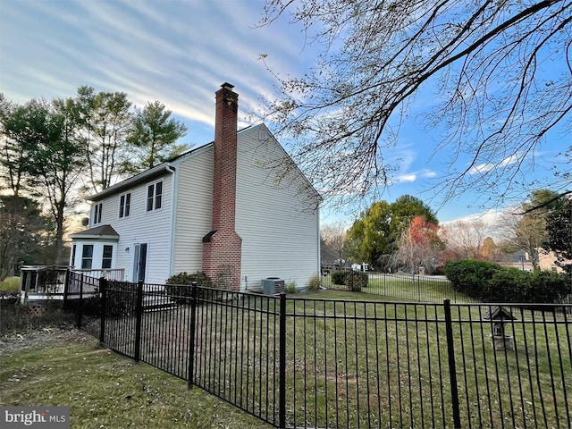 view of side of property featuring central air condition unit and a yard