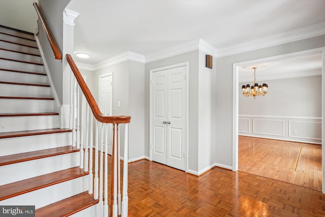 staircase with a notable chandelier, ornamental molding, and parquet floors