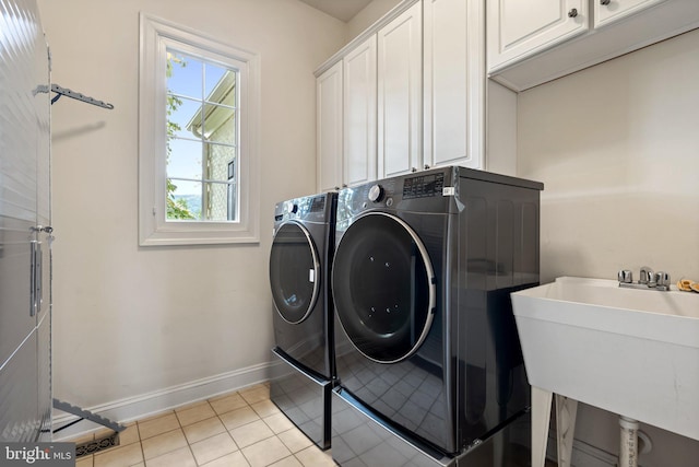 washroom with separate washer and dryer, sink, cabinets, and light tile patterned flooring