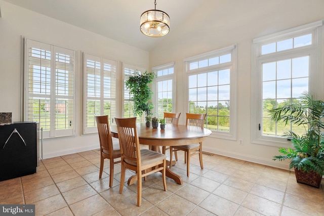 tiled dining area featuring lofted ceiling, a chandelier, and a healthy amount of sunlight