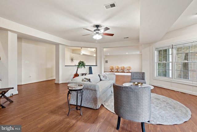 living room featuring ceiling fan and dark hardwood / wood-style floors