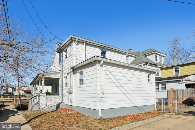 view of side of home with a gate and fence