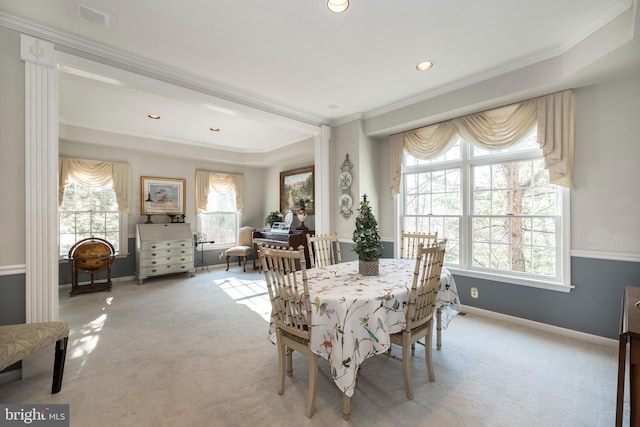 carpeted dining room with ornamental molding