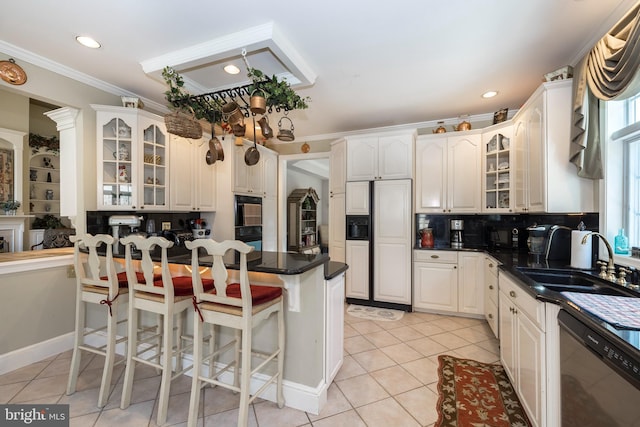 kitchen with black appliances, plenty of natural light, white cabinetry, and sink