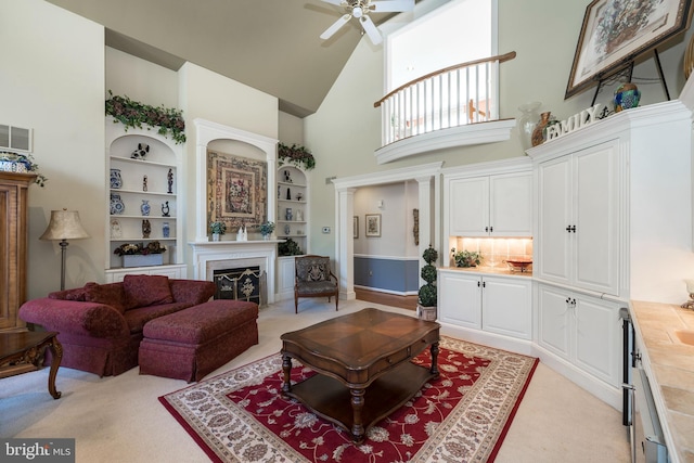 living room featuring built in features, light carpet, high vaulted ceiling, and ceiling fan