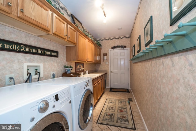 clothes washing area featuring cabinets, rail lighting, sink, washer and dryer, and light tile patterned floors