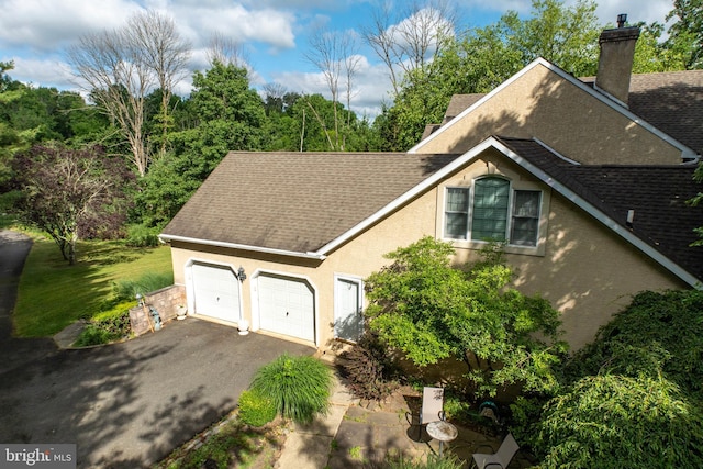 view of side of property featuring a garage and a yard