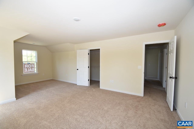 unfurnished room featuring light colored carpet and lofted ceiling