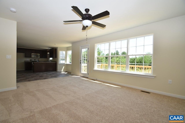 unfurnished living room featuring carpet flooring and ceiling fan