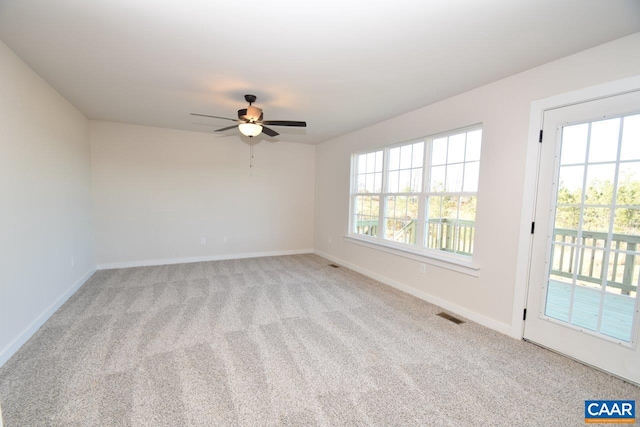 carpeted empty room featuring ceiling fan and a healthy amount of sunlight