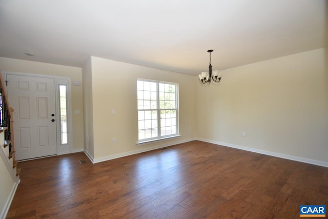 foyer entrance with dark hardwood / wood-style floors and a notable chandelier