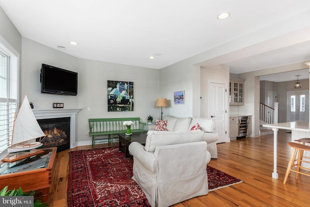 living room with hardwood / wood-style flooring, a healthy amount of sunlight, and wine cooler