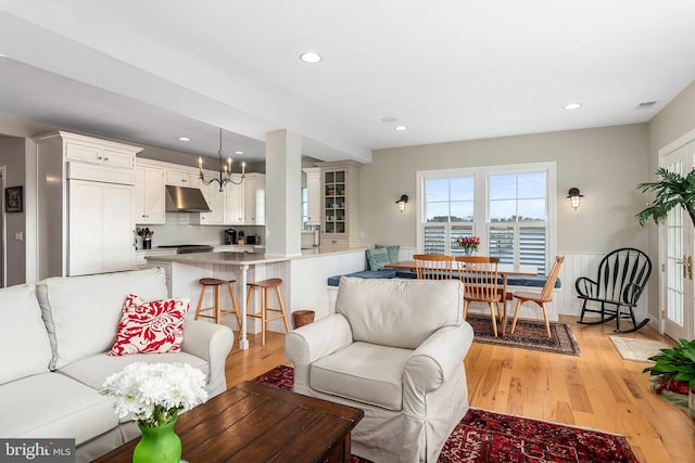 living room with light hardwood / wood-style flooring and a notable chandelier