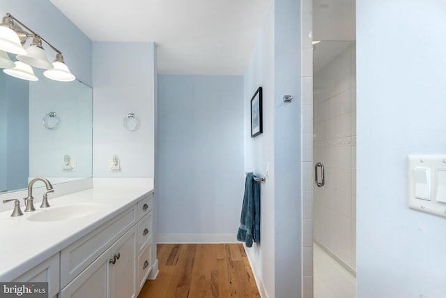 bathroom with hardwood / wood-style floors, vanity, and walk in shower