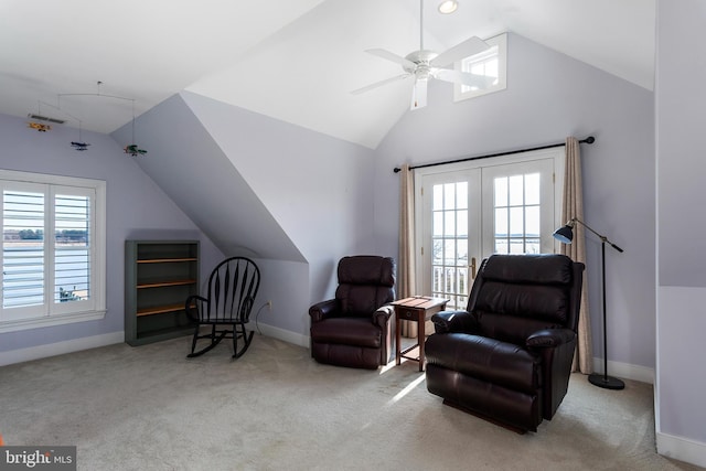 sitting room with ceiling fan, plenty of natural light, light colored carpet, and lofted ceiling