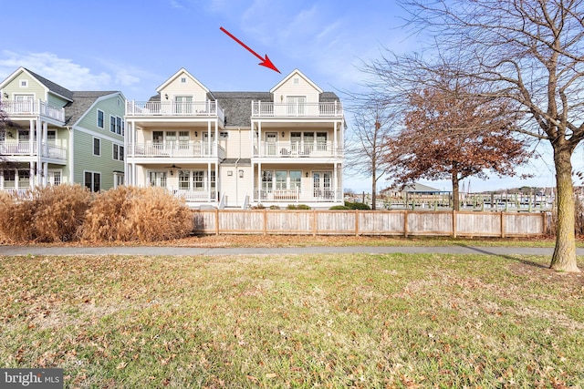 rear view of property with a yard and a balcony