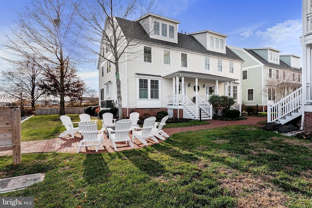 rear view of house featuring a porch, a yard, and cooling unit