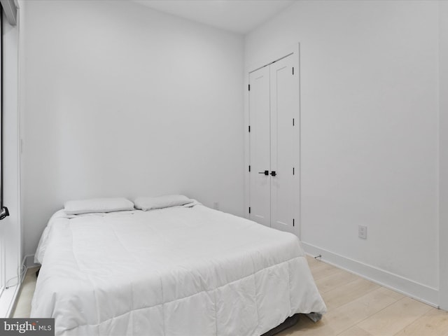 bedroom with a closet and light hardwood / wood-style flooring