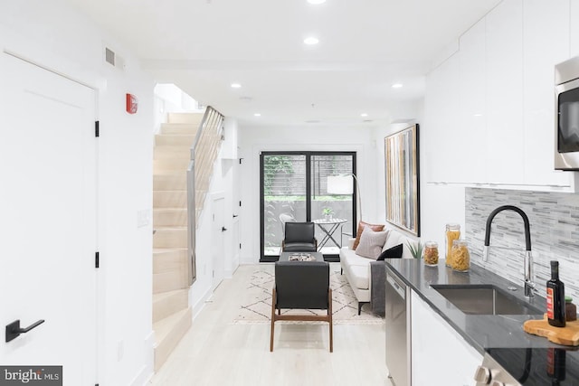 living room with light hardwood / wood-style floors and sink