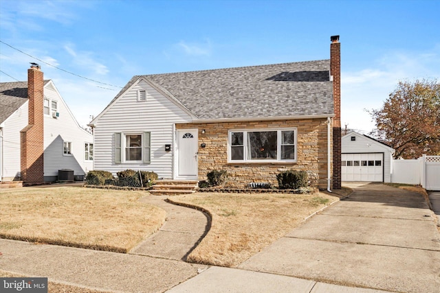 view of front of home featuring an outbuilding, cooling unit, a front yard, and a garage