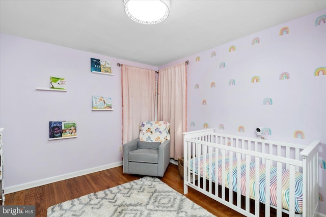 bedroom featuring dark hardwood / wood-style flooring and a crib