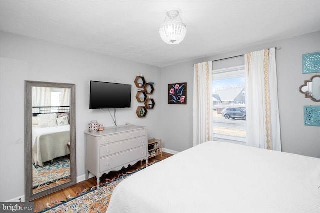 bedroom featuring a notable chandelier and wood-type flooring