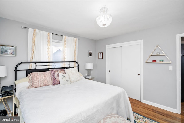 bedroom with dark hardwood / wood-style flooring and a closet