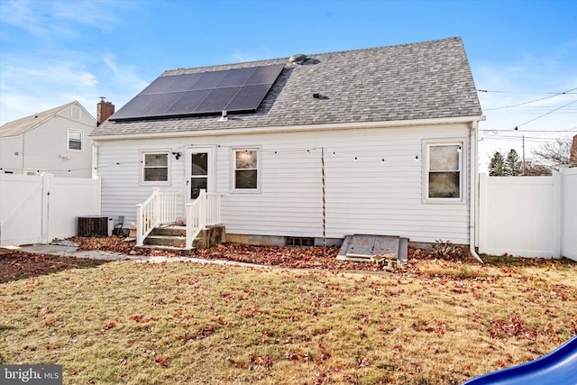 rear view of property featuring a lawn and cooling unit