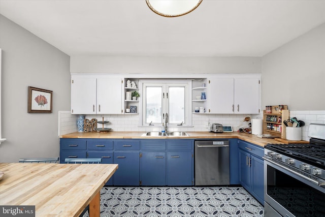 kitchen featuring white cabinetry, blue cabinets, wooden counters, and appliances with stainless steel finishes