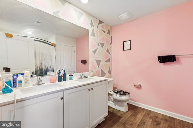 bathroom with walk in shower, hardwood / wood-style floors, vanity, and toilet