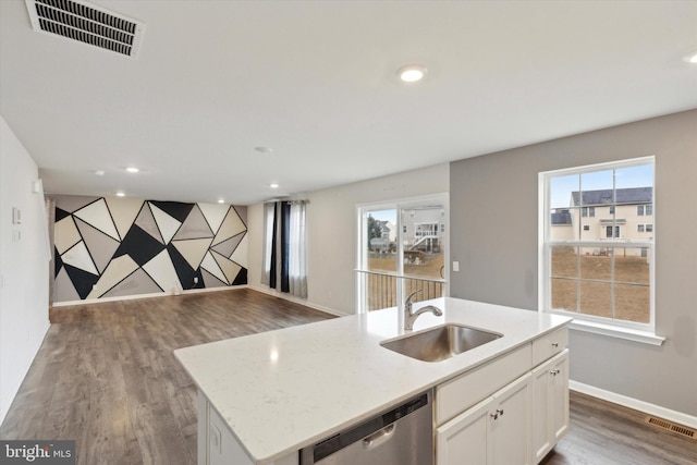 kitchen featuring sink, white cabinetry, light stone counters, an island with sink, and stainless steel dishwasher