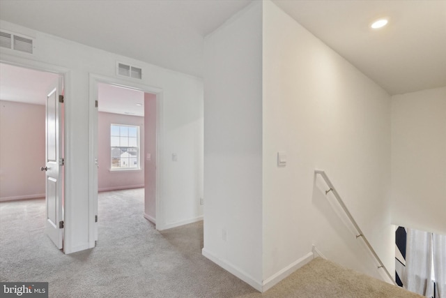 corridor featuring light colored carpet