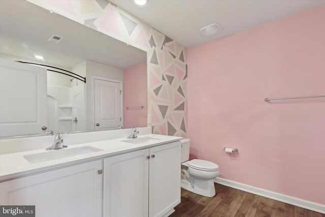 bathroom with vanity, a shower, hardwood / wood-style floors, and toilet