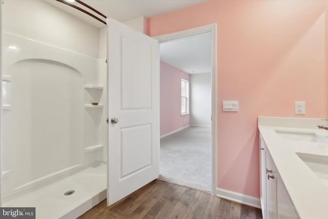 bathroom featuring vanity, hardwood / wood-style floors, and a shower