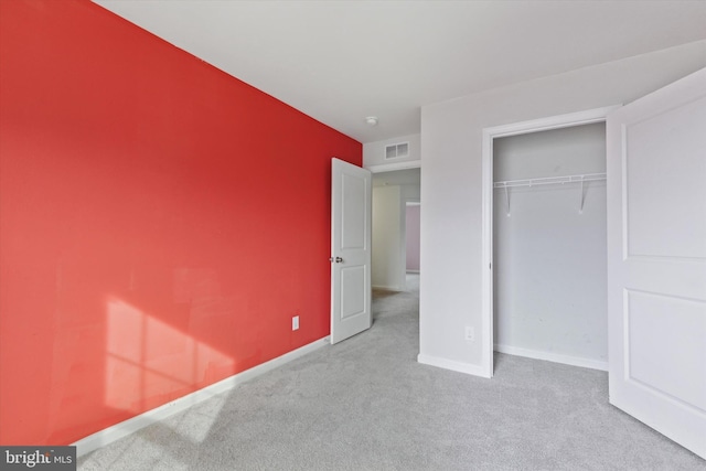 unfurnished bedroom with light carpet and a closet