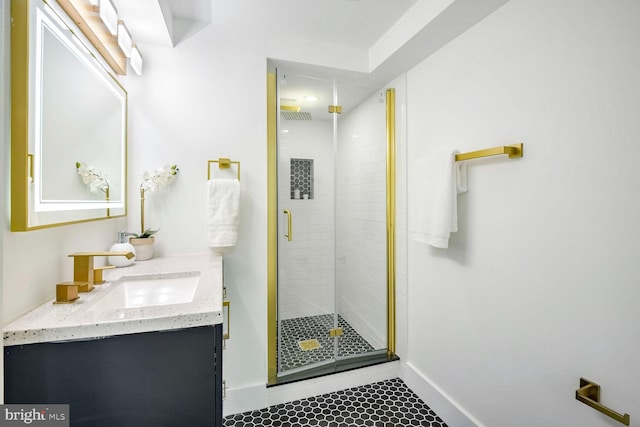 bathroom featuring a shower with door and vanity