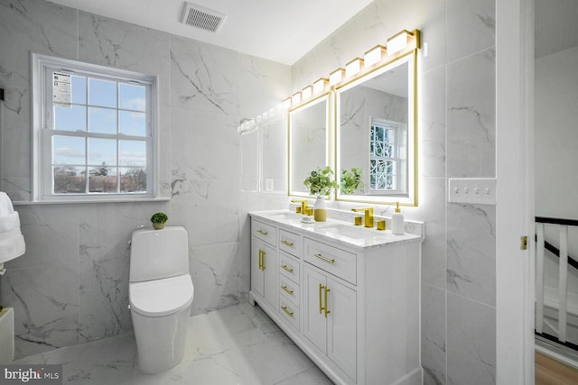 bathroom featuring vanity, tile walls, and toilet