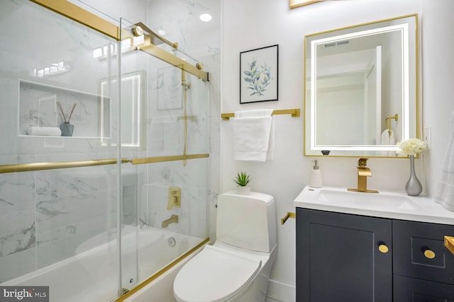 full bathroom featuring vanity, toilet, and bath / shower combo with glass door