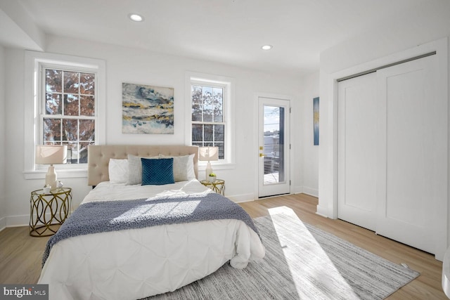 bedroom featuring access to exterior, light hardwood / wood-style floors, and a closet