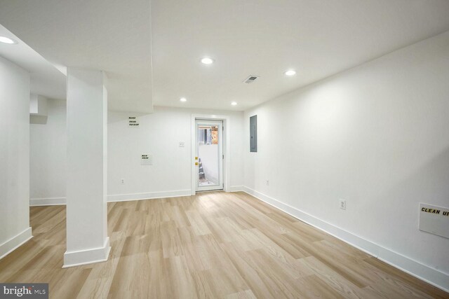 empty room featuring electric panel and light hardwood / wood-style flooring