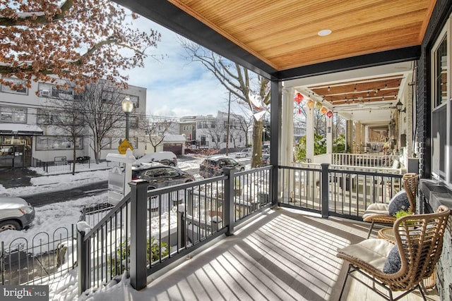 snow covered deck with a porch