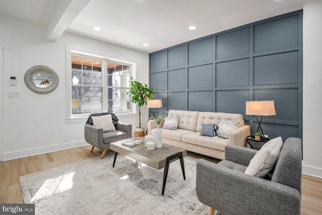 living room featuring beam ceiling and light hardwood / wood-style flooring