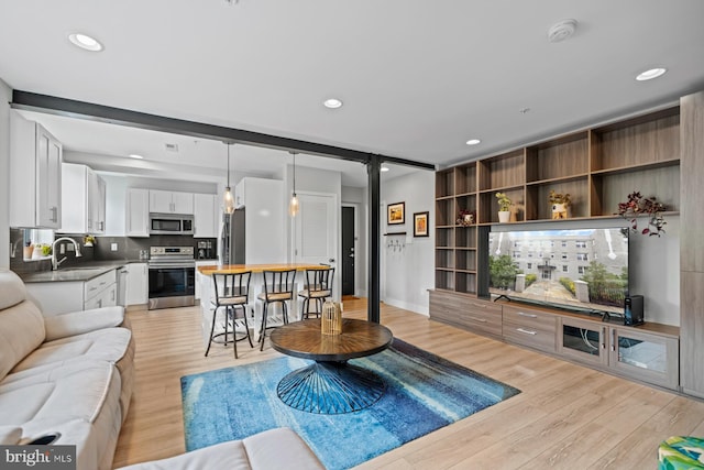 living room with light hardwood / wood-style floors and sink