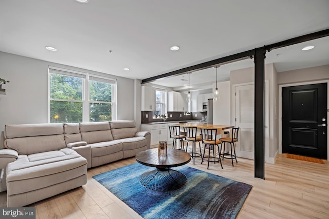 living room featuring light wood-type flooring and sink