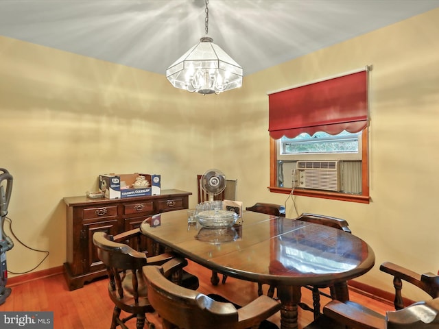 dining space with hardwood / wood-style floors, cooling unit, and a chandelier