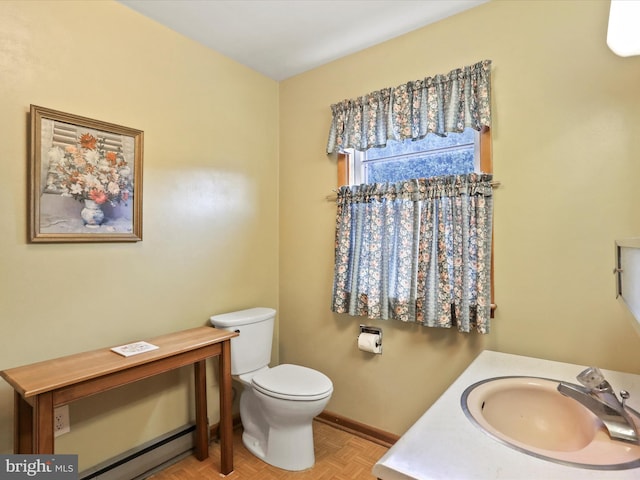 bathroom with vanity, toilet, and parquet floors